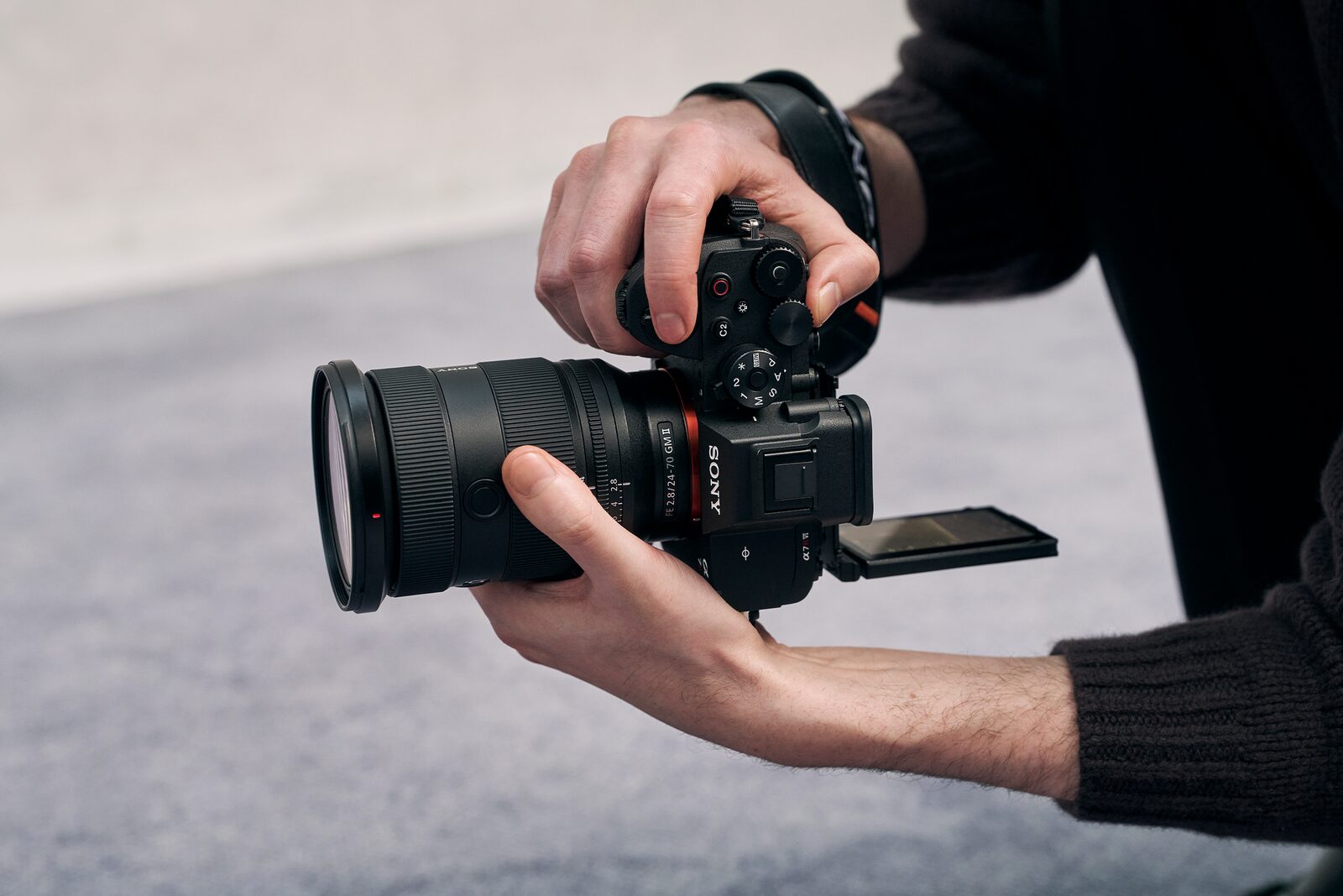 Sony A7R VI 配 FE 24-70mm F2.8 GM II，用家雙手握機並翻開 4 軸多角度屏幕